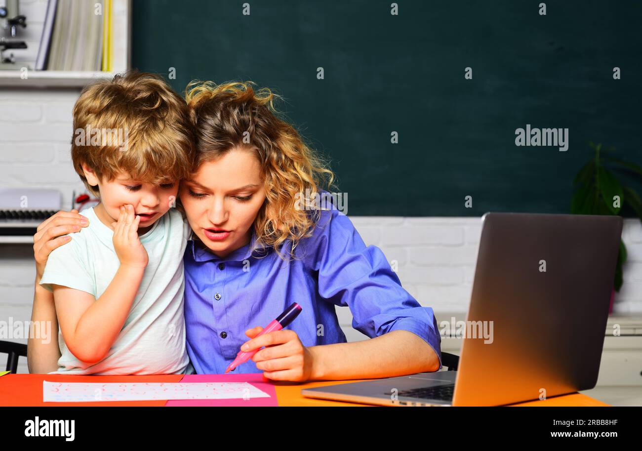 Mathematics for kids. Little boy studying, doing homework with mother. Female teacher giving private lessons to kid at home. Female teacher helping Stock Photo