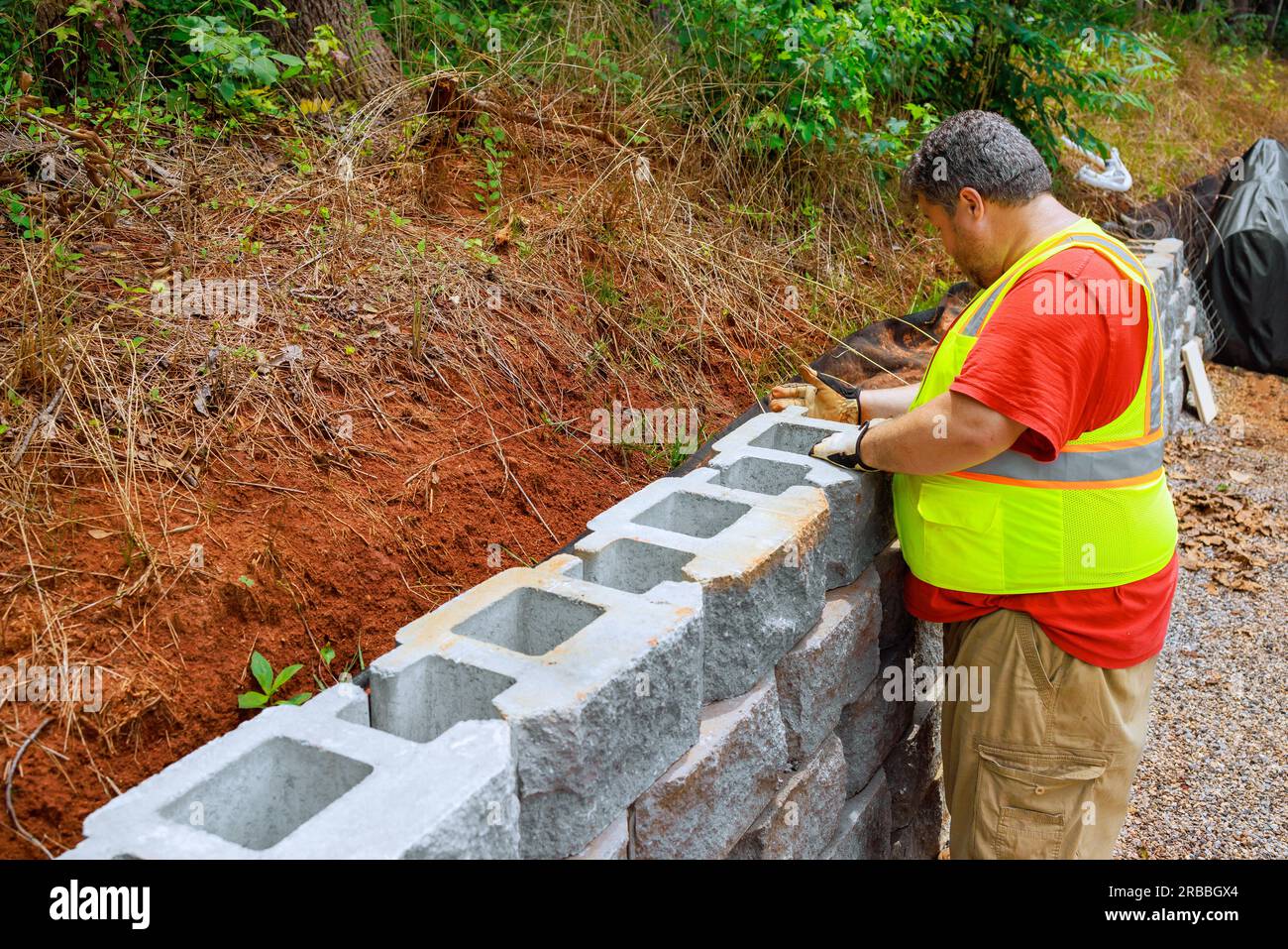 Construction worker was mounting concrete blocks to retaining wall on