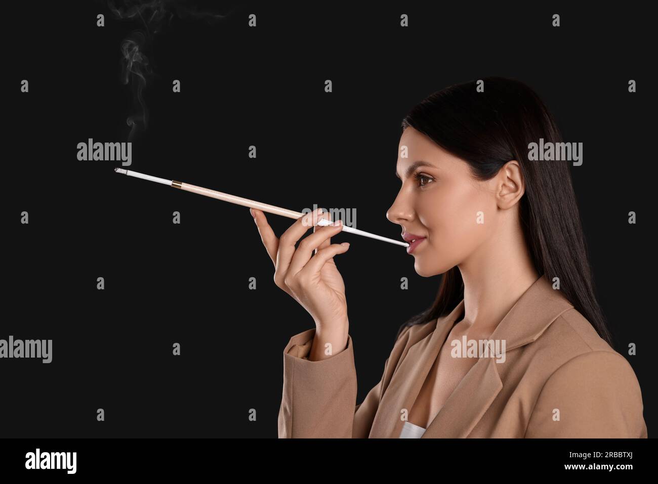 cigarette holder for smoking Woman using long cigarette holder for smoking on black background Stock  Photo