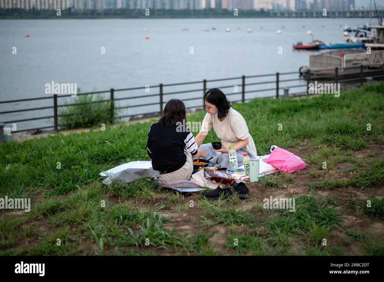 People picnicing in Yeouido park on Han river in Seoul, South Korea on 24 June 2023 Stock Photo