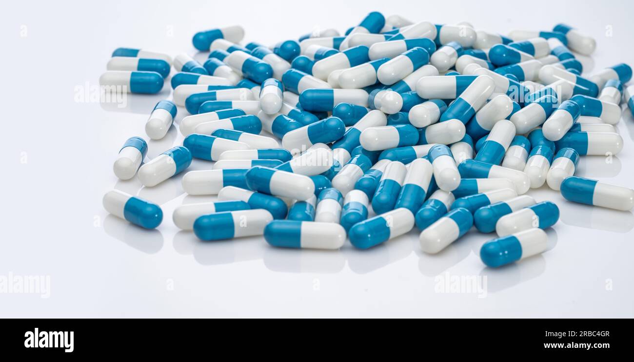 Bluewhite antibiotic capsule pills on white background. Pile of antibiotic drug. Antibiotic