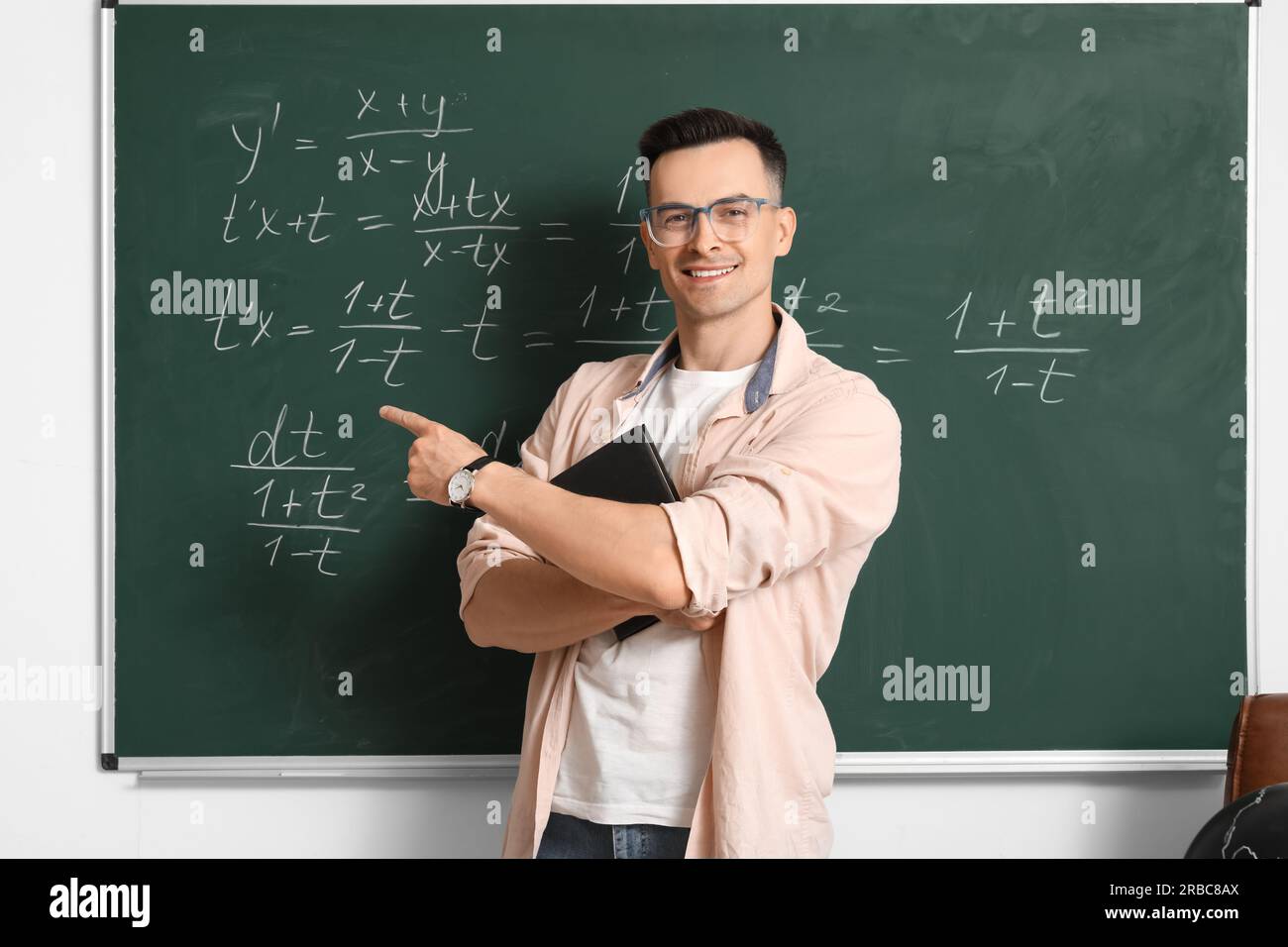 Male Math teacher conducting lesson near chalkboard in classroom Stock ...