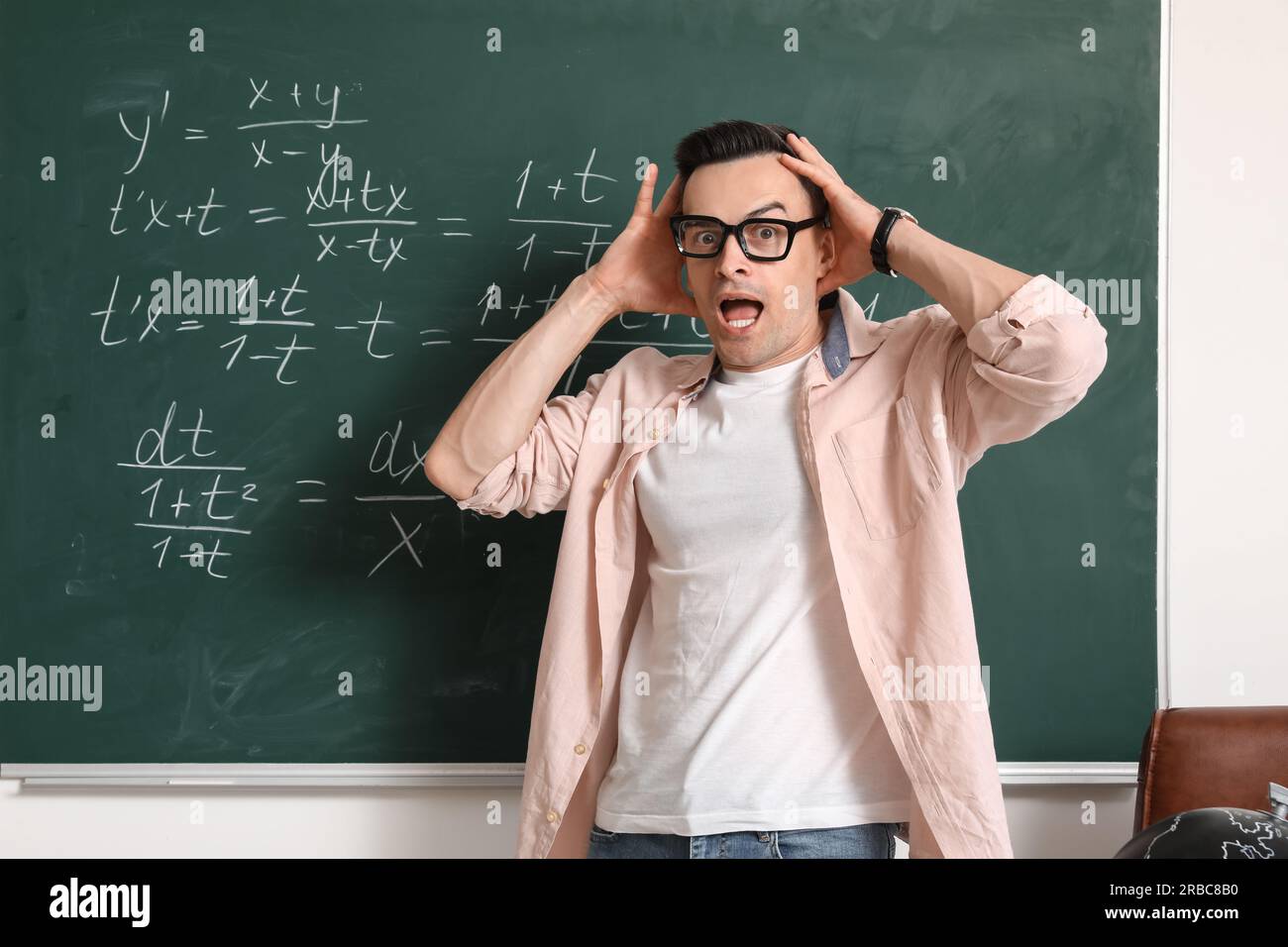 Shocked Math teacher near chalkboard in classroom Stock Photo - Alamy