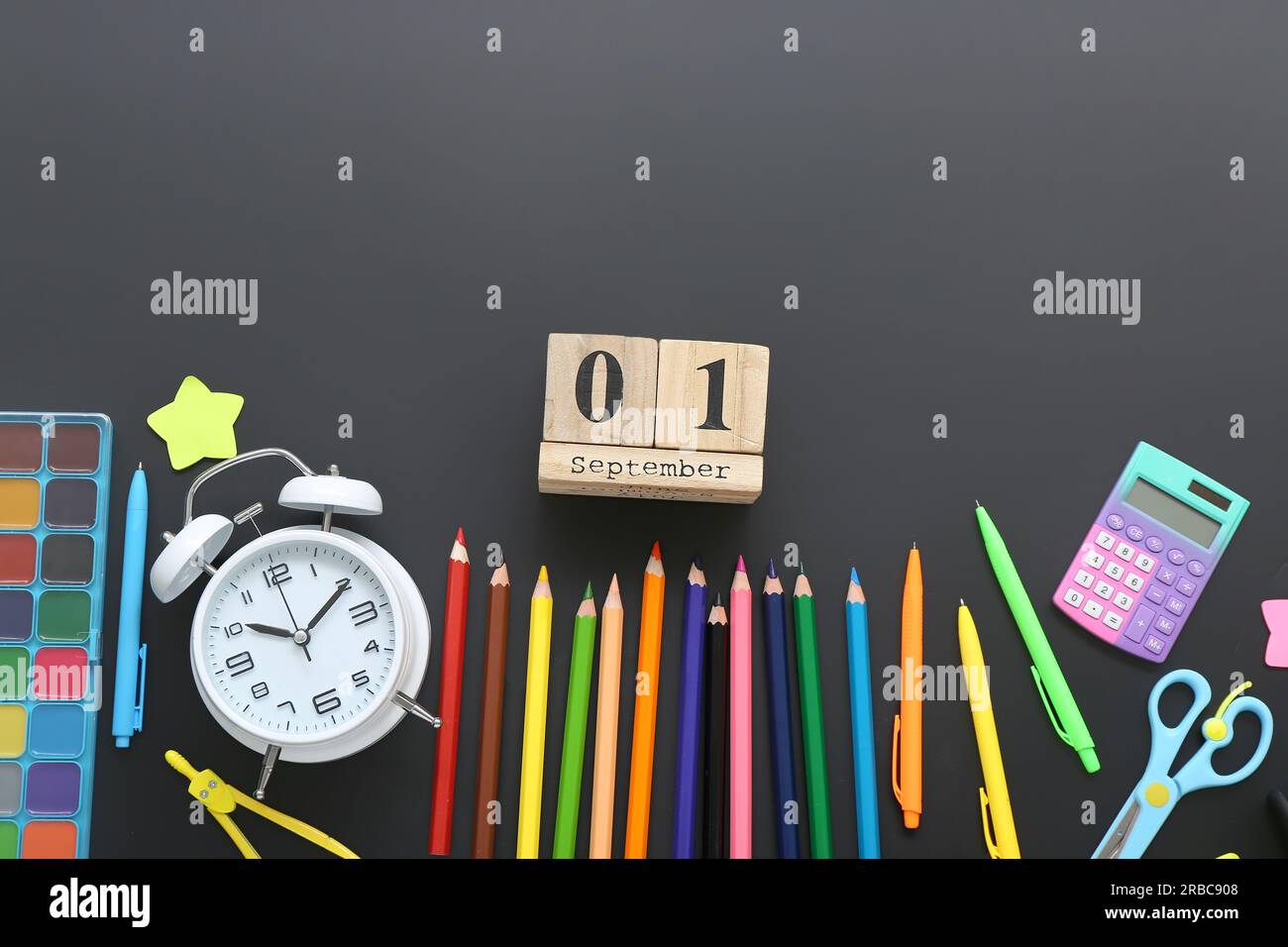 Alarm clock, different stationery and calendar with date SEPTEMBER 1 on black chalkboard Stock