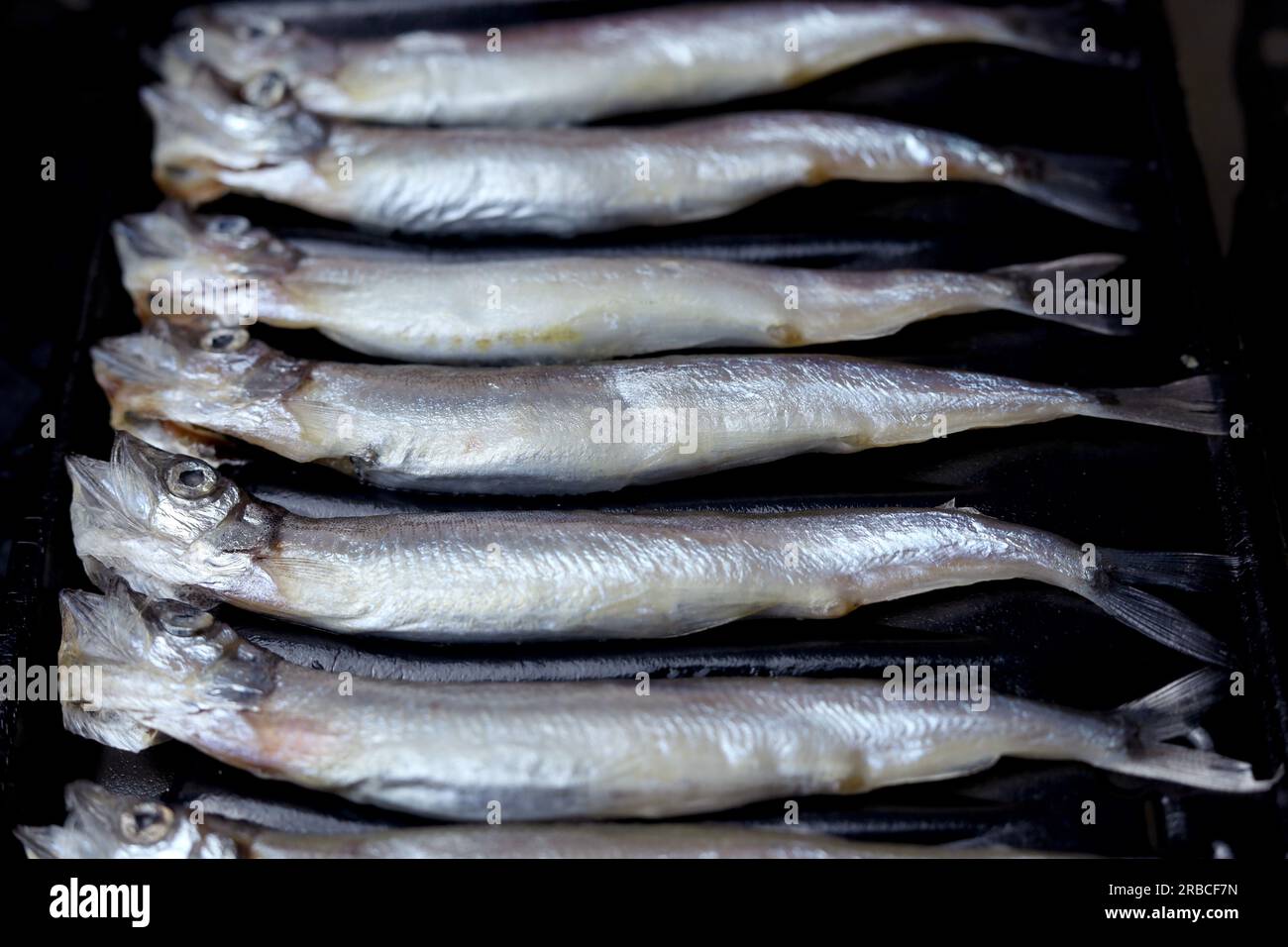 Fresh raw capelin fish on black background Stock Photo