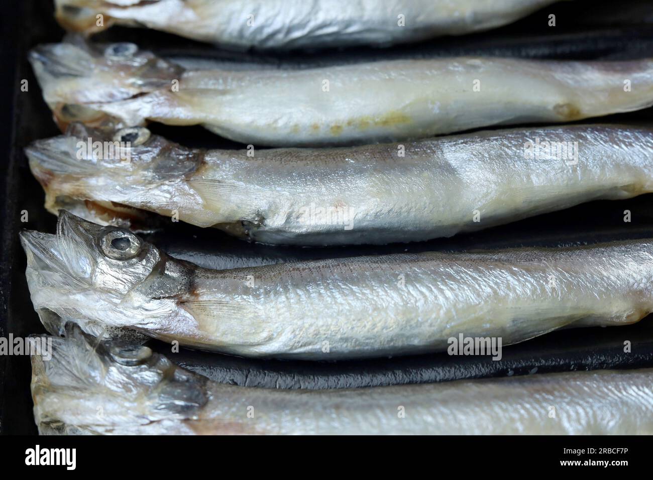 Fresh raw capelin fish on black background Stock Photo - Alamy