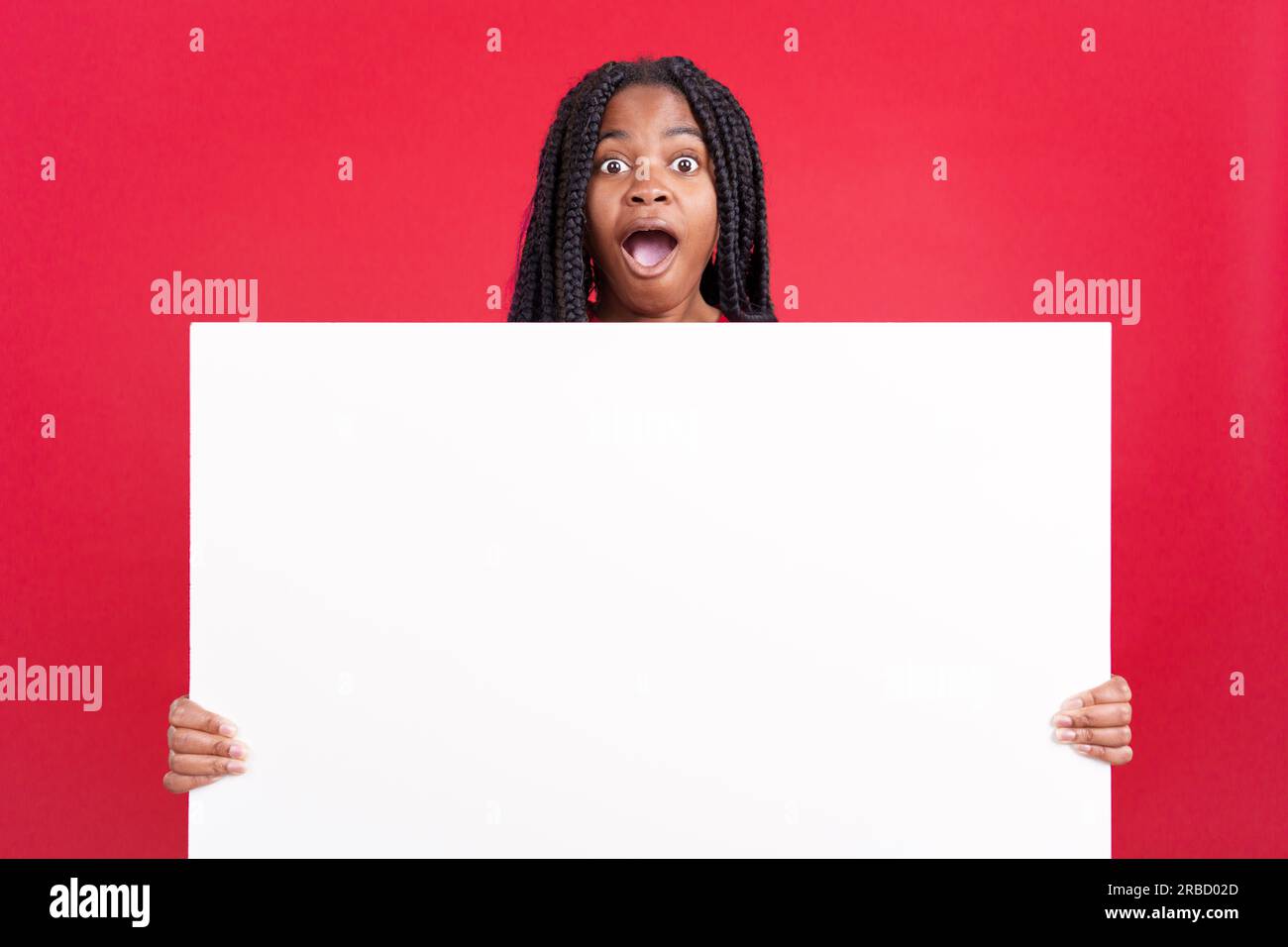 Surprised african woman holding a blank panel Stock Photo - Alamy