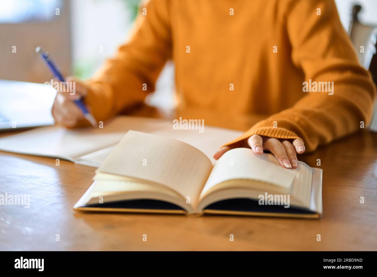 Asian woman's hand studying for qualifications Stock Photo