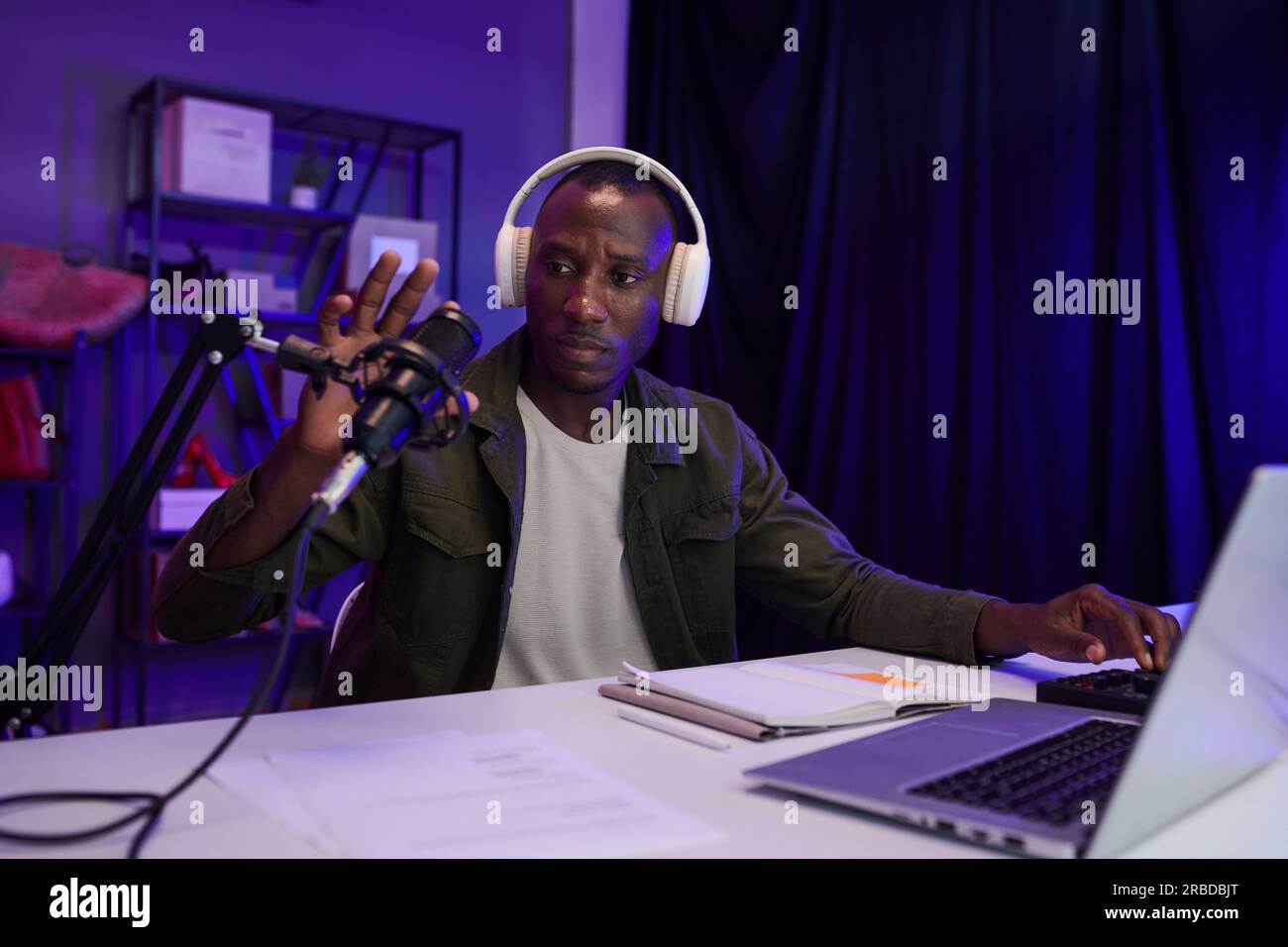 Serious blogger checking microphone before recording podcast Stock Photo