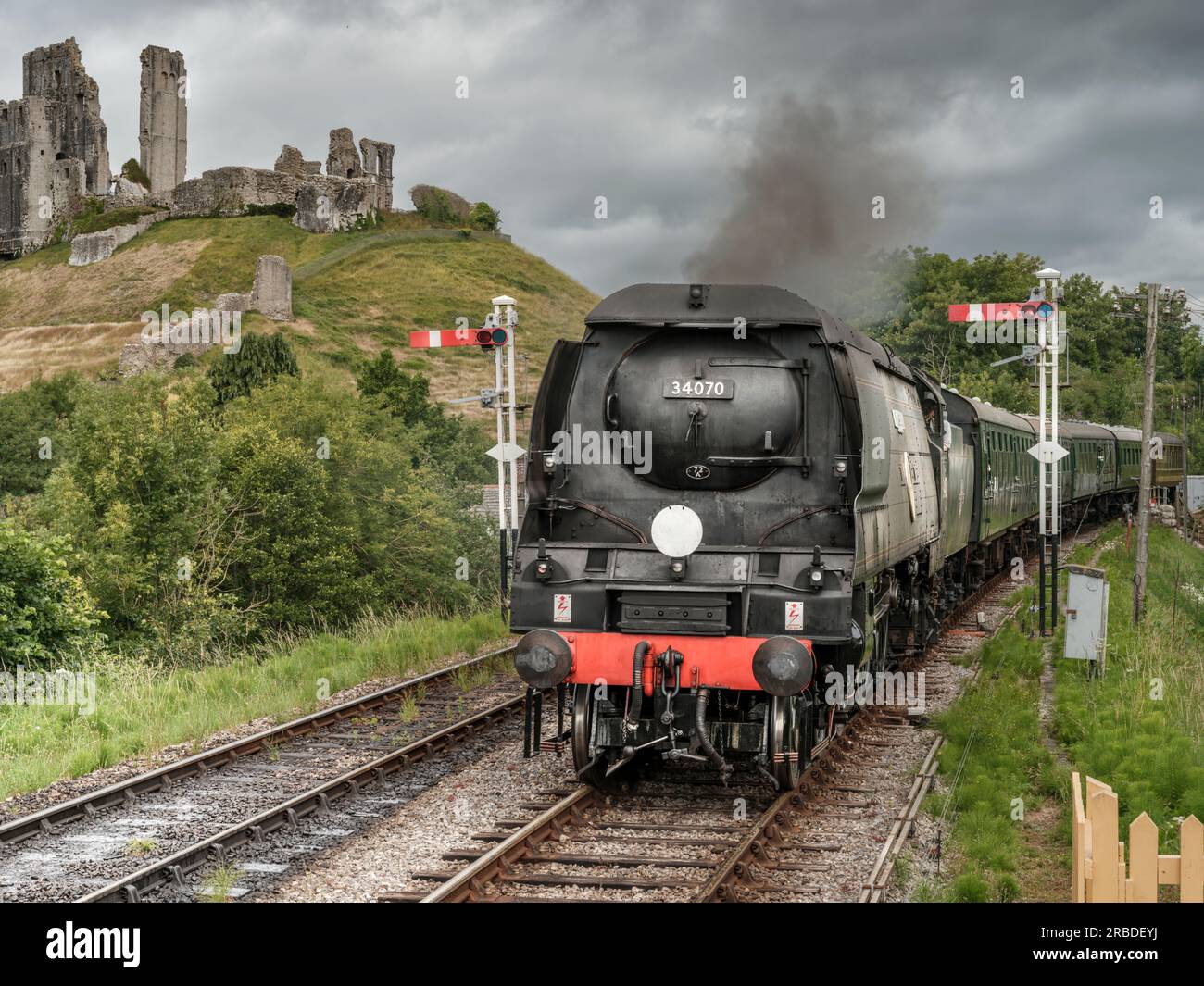 A steam engine approaches Corfe Castle Railway Station. The award winning Swanage Railway Company is volunteer-led and runs between Wareham and Swanag Stock Photo