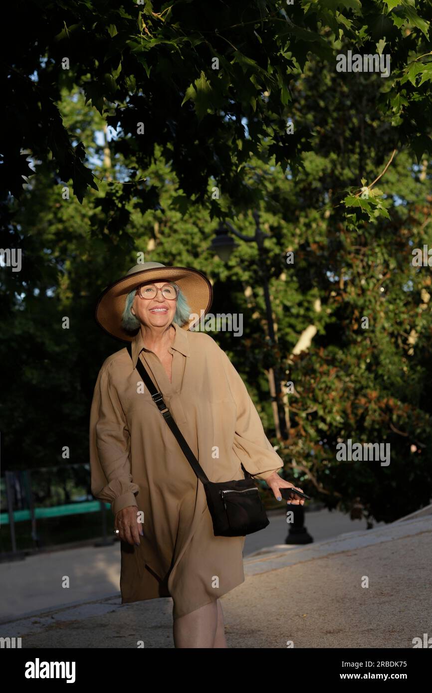 full body of happy older woman with hat outdoors Stock Photo