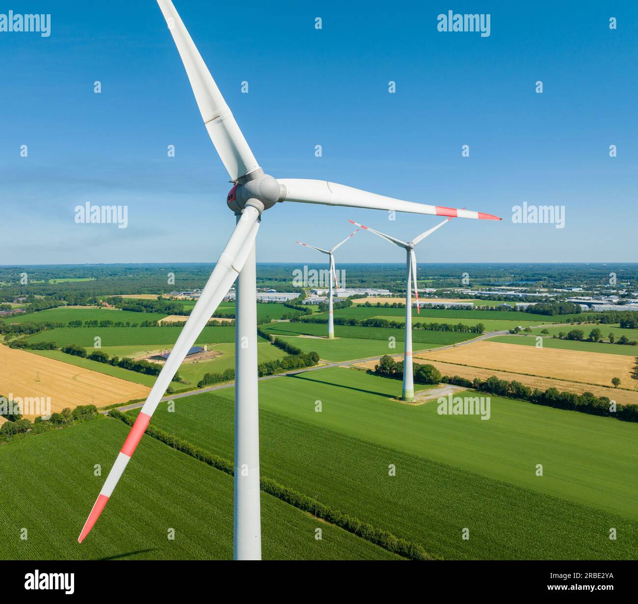 three wind turbines in an agricultural landscape seen from the air Stock Photo