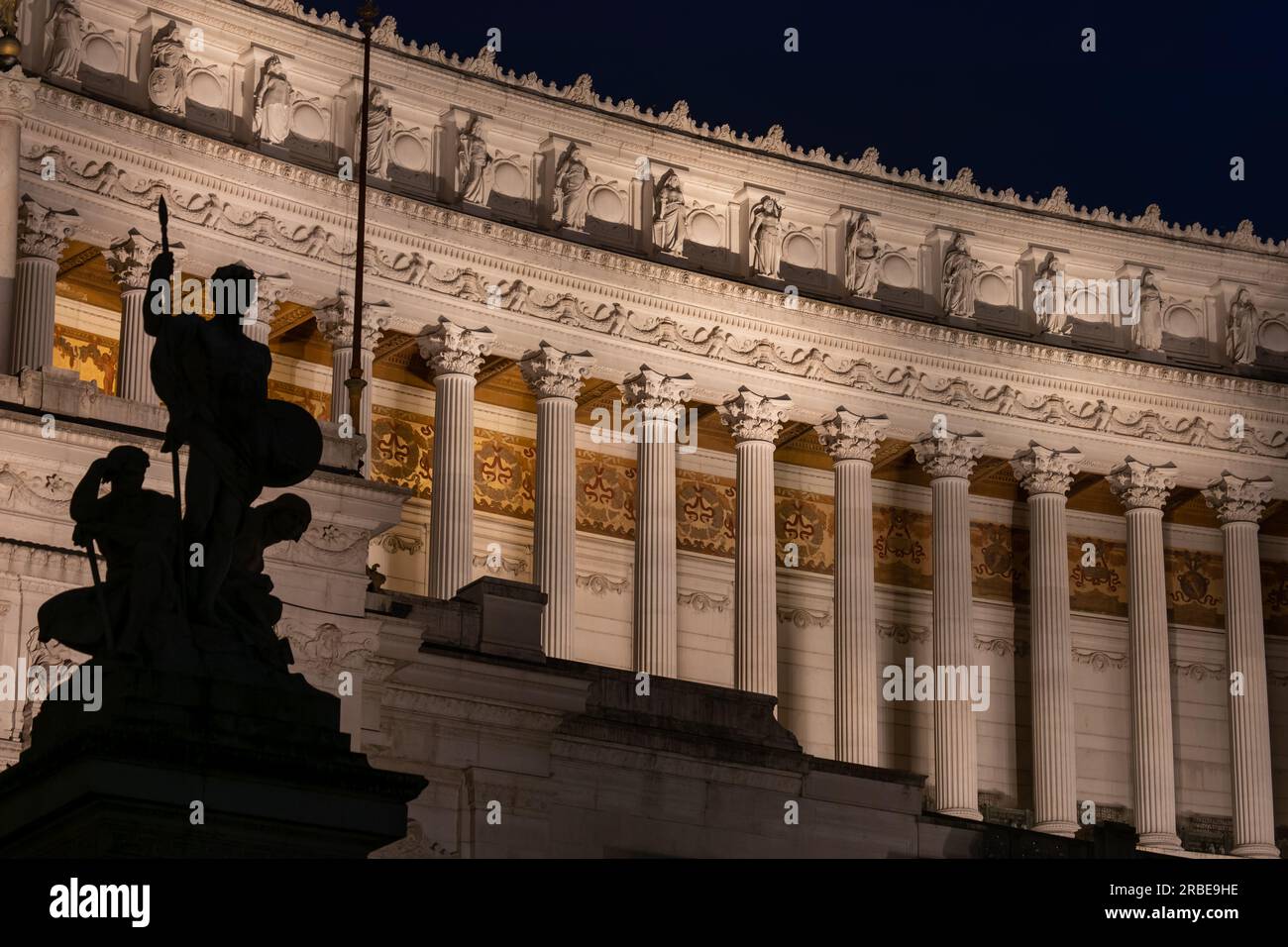 The Vittoriano Neoclassical colonnade illuminated at night in city of Rome, Italy. Monument to Victor Emmanuel II, Corinthian columns of the portico w Stock Photo