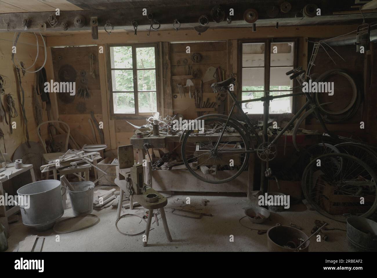 Cluttered Wooden Shop with Bicycle and Vintage Tools Stock Photo