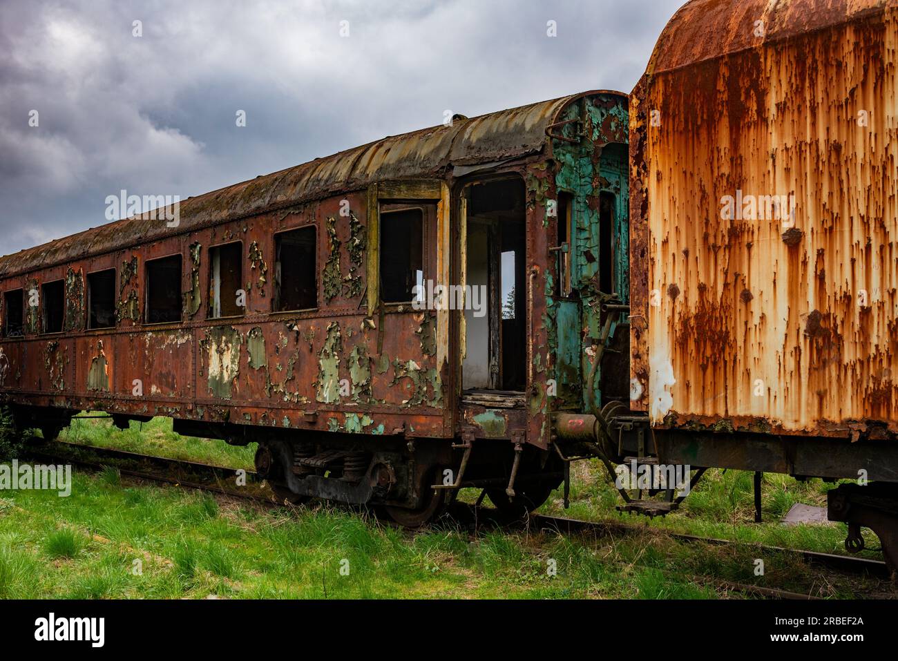 Old rusty passenger railway carriage abandoned on train cemetary field Stock Photo