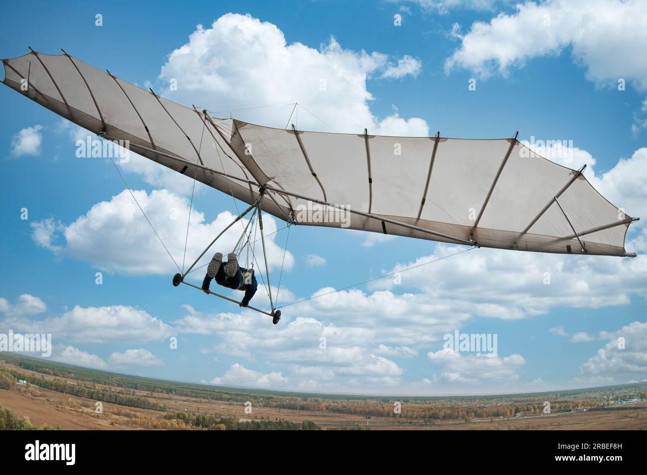 Vintage white hang glider flies to the sky. View from the back. Learning to fly. Dream of flying. Stock Photo