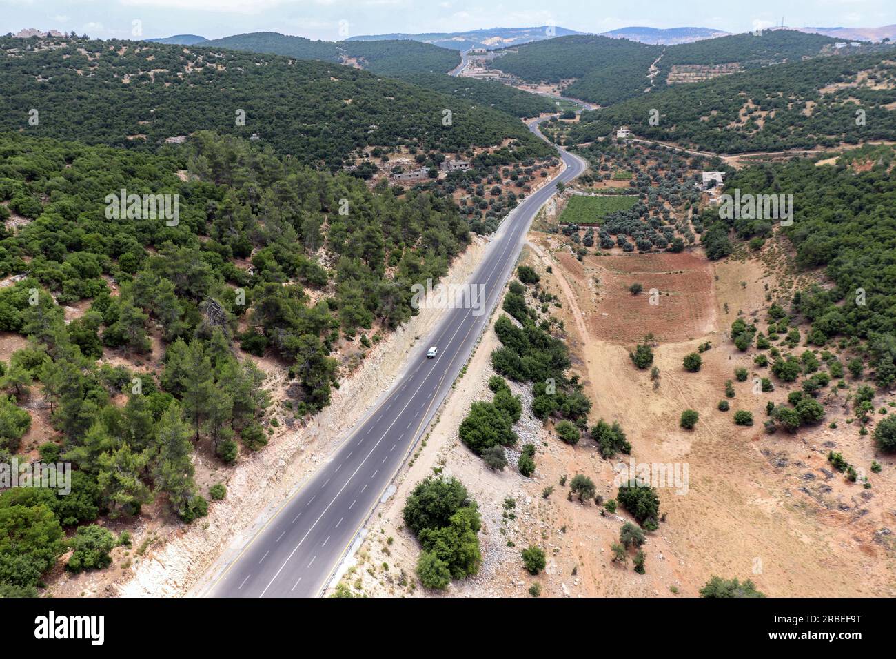 Travel among cities - An aerial view of the forests, trees, mountains of Ajloun, its streets and roads taken from the Ajloun cable car (Ajloun, Jordan Stock Photo