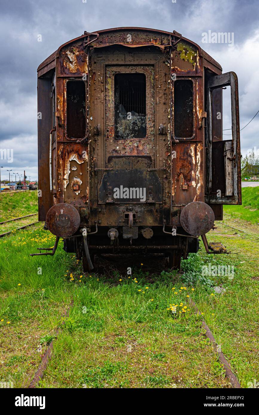 Old rusty passenger railway carriage abandoned on train cemetary field Stock Photo