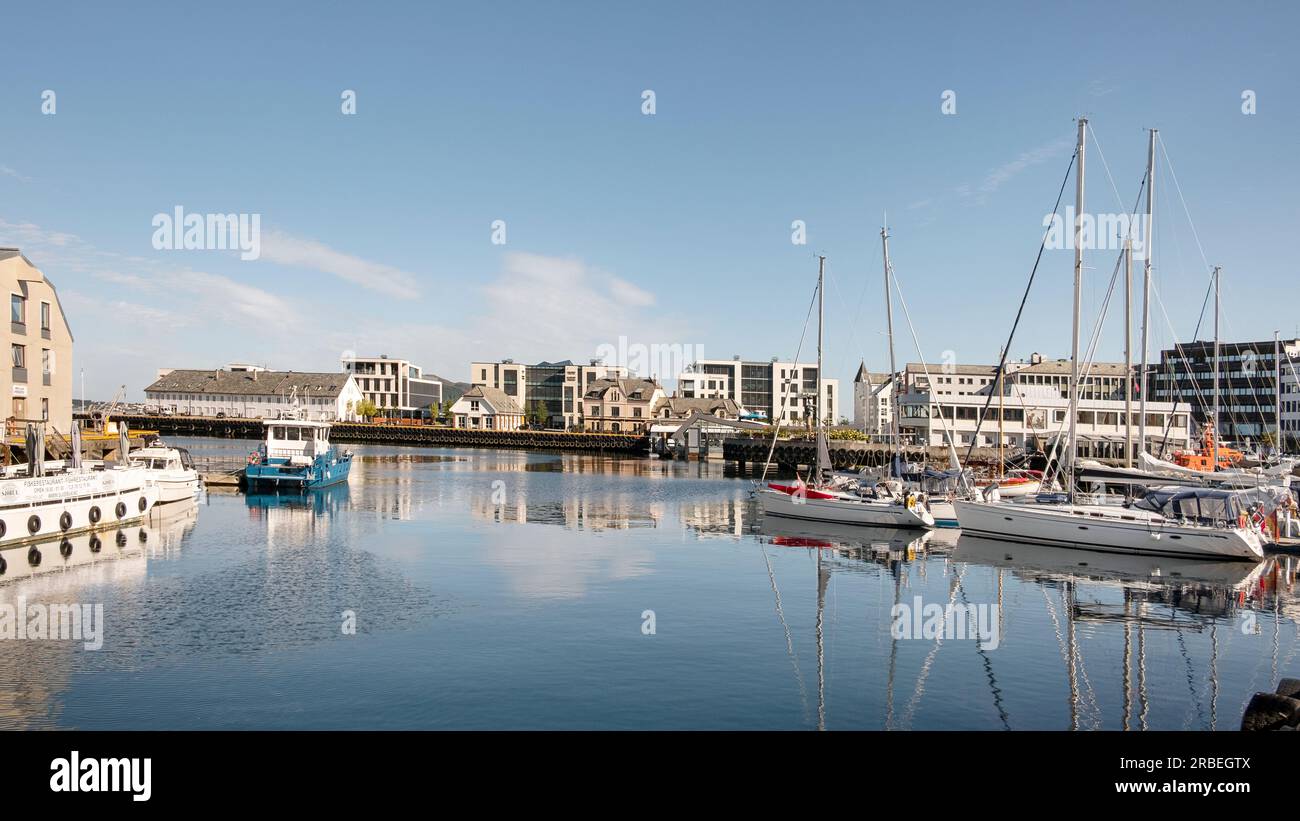 Morning views of the charming bay with elegant yachts and traditional fishing boats moored in the tranquil waters with the picturesque coastal town Stock Photo