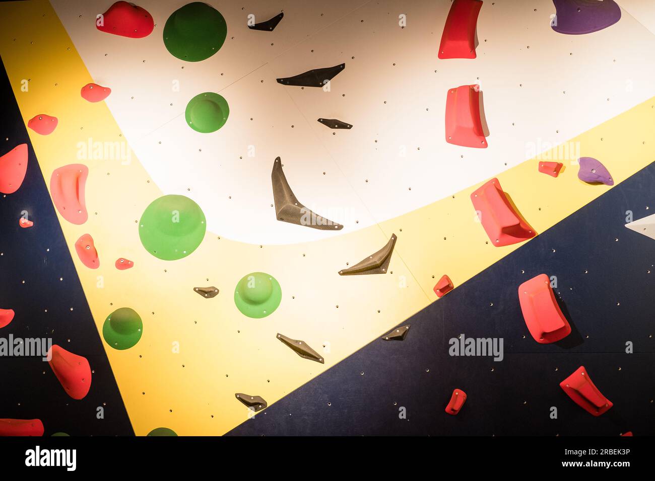 Colorful rock climbing wall with toe and hand hold studs. Wall climbing background. Stock Photo