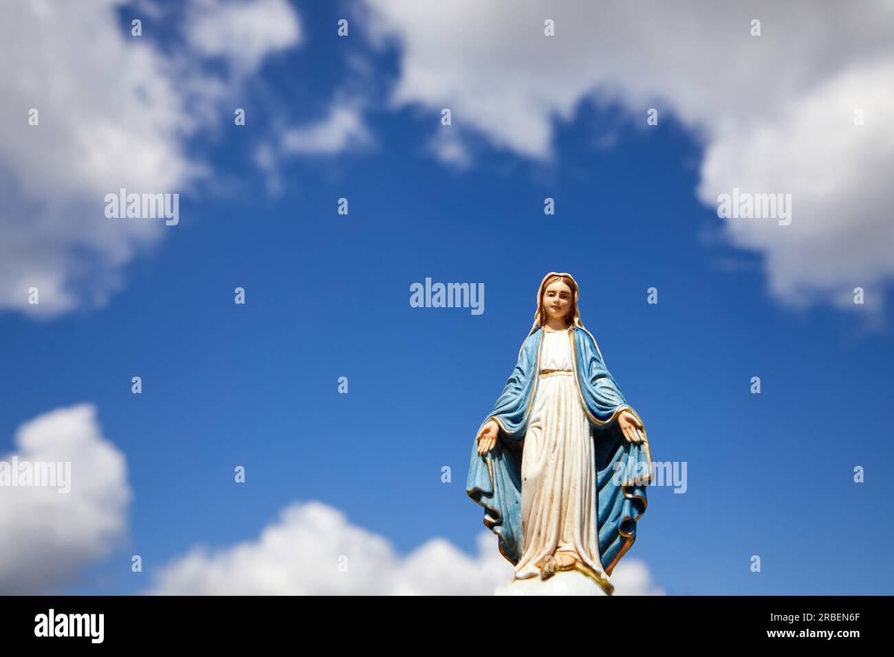 Assumptio of Mary. Virgin Mary statue with the blue sky with white