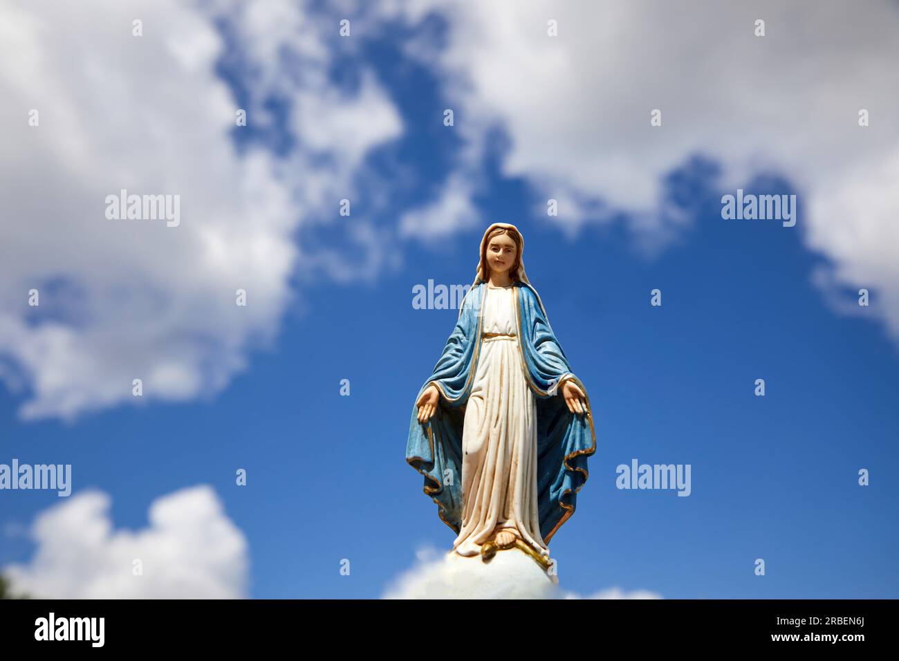 Assumptio of Mary. Virgin Mary statue with the blue sky with white