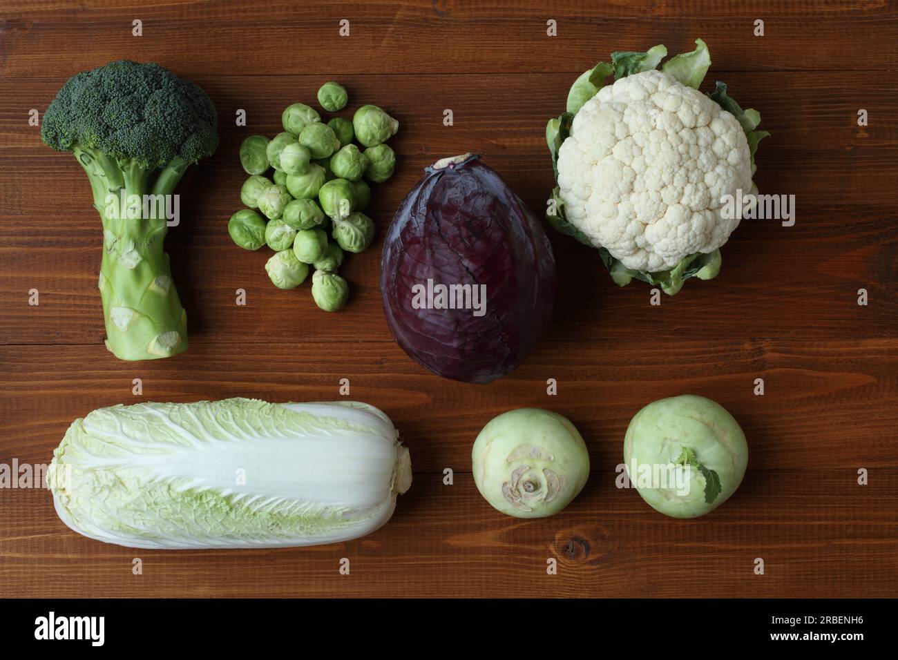 Different types of cabbage on a brown wooden table. View from above. Closeup. Broccoli, Brussels sprouts, kohlrabi, cauliflower, red cabbage, Chinese Stock Photo