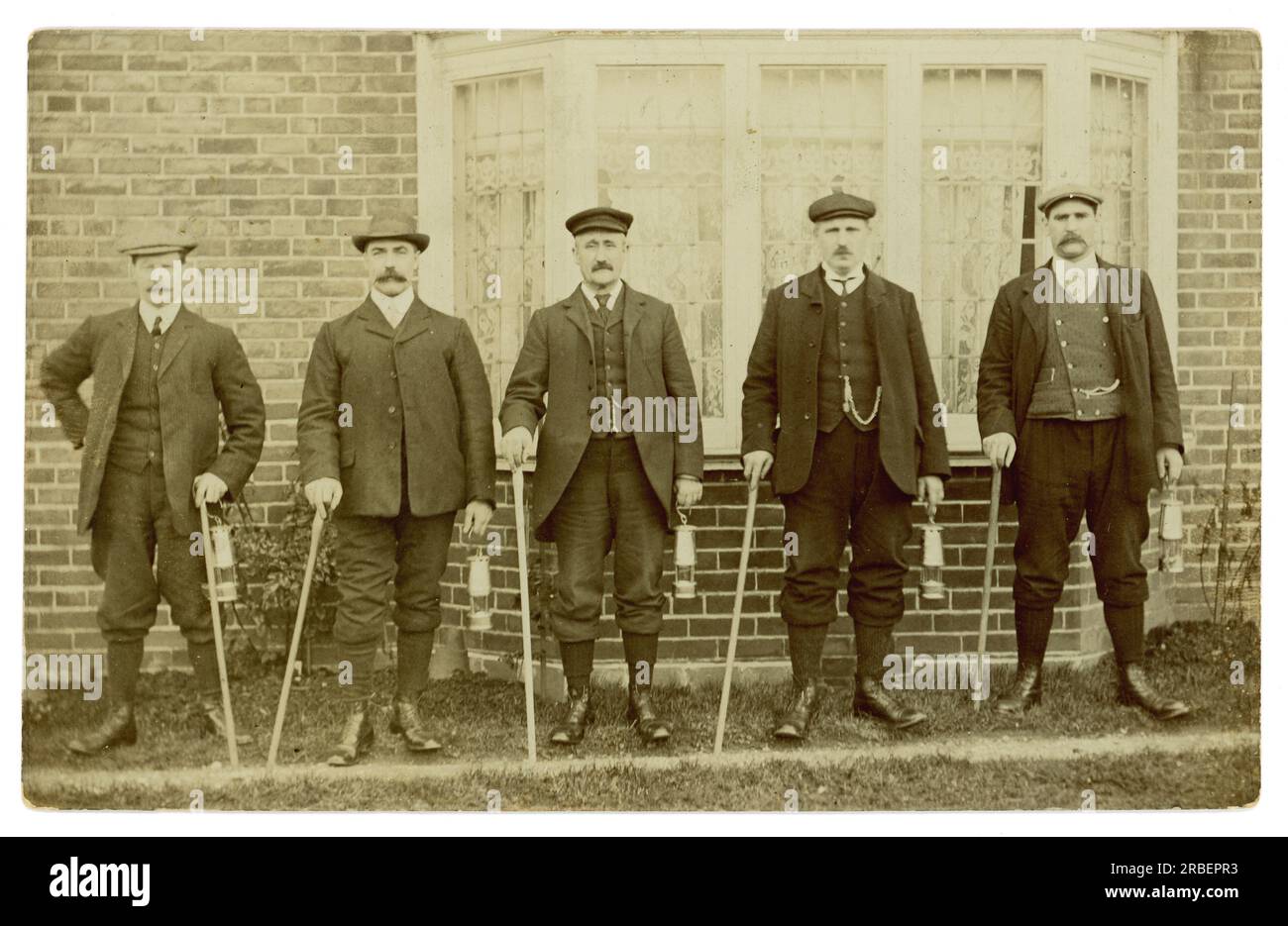 Original Edwardian era postcard of 5 men posing for a photograph together, carrying miners safety lamps, dressed in Sunday best for a walk, possibly miners going for a Sunday hike, possibly estate workers. circa 1910 U.K. Stock Photo