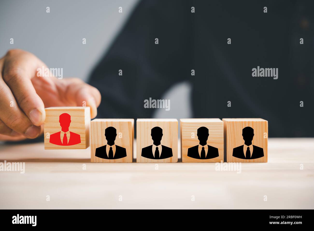 Hand reaching for red human icon on wooden block Stock Photo - Alamy