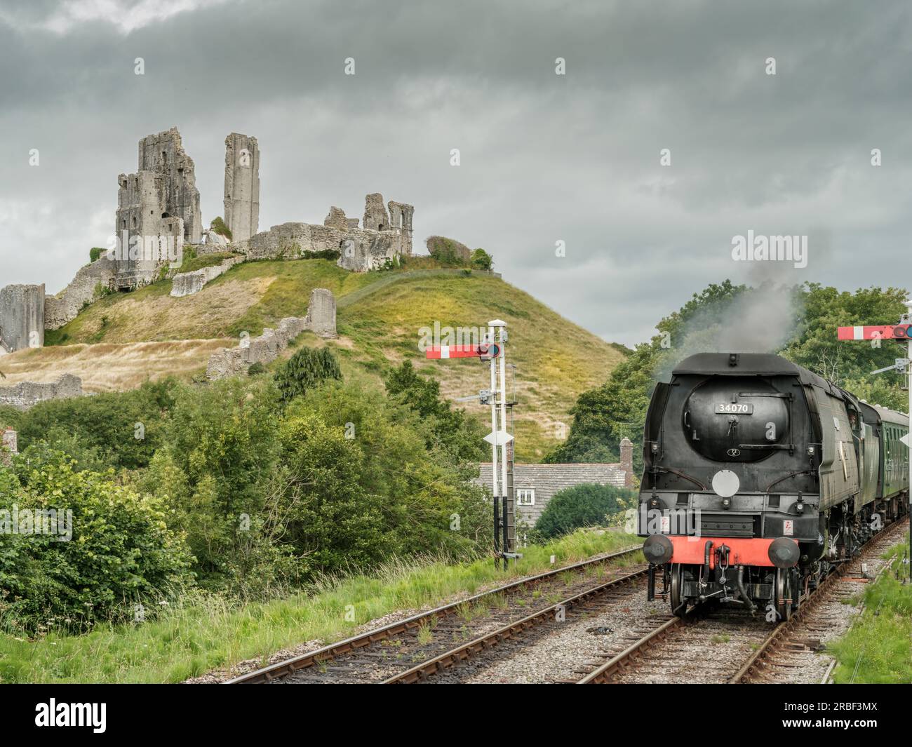 A steam engine approaches Corfe Castle Railway Station. The award winning Swanage Railway Company is volunteer-led and runs between Wareham and Swanag Stock Photo