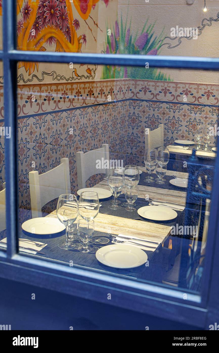 Tables set inside a Small Restaurant with Walls decorated with Colorful