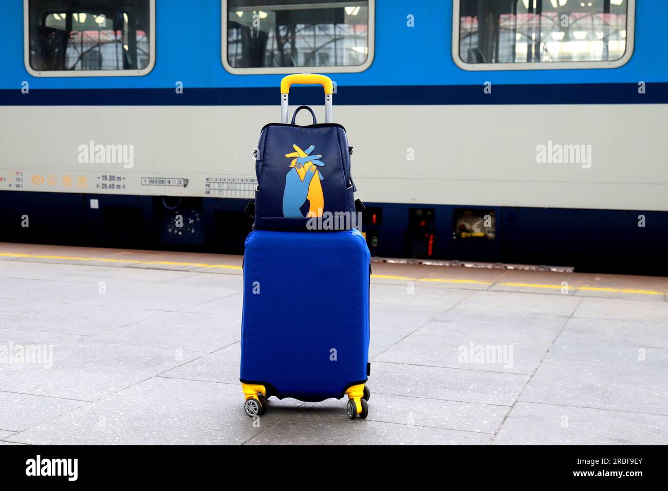 Suitcase and bag in colors of Ukraine flag at railway station, Prague
