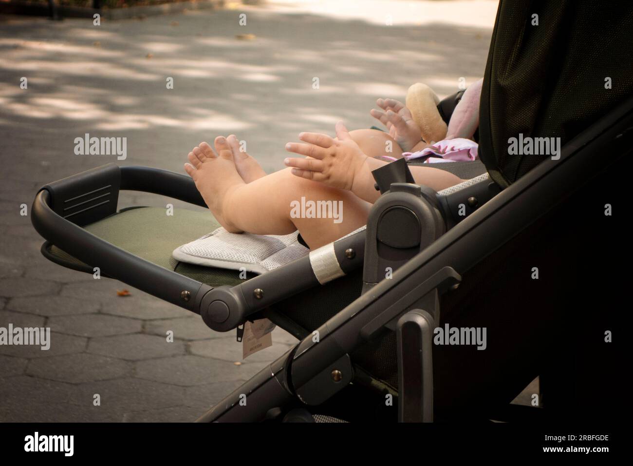 Hands and feet of a little baby in a stroller Stock Photo