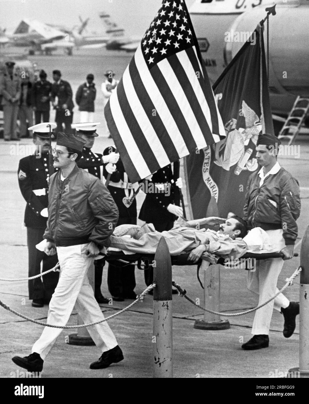 Alameda, California:  February 18, 1973 Wounded U.S. Air Force POW Roy Madden Jr. salutes the flag as he's carried from the plane on a litter. Stock Photo