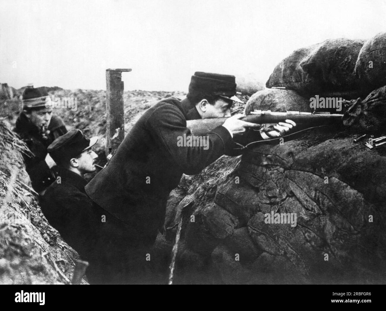 Belgium:  1914 These soldiers are in the frst line of the trenches. The soldiers fire through loop holes in the sandbags and earthworks, and others can use the periscope to see what is happening on the other side. Stock Photo
