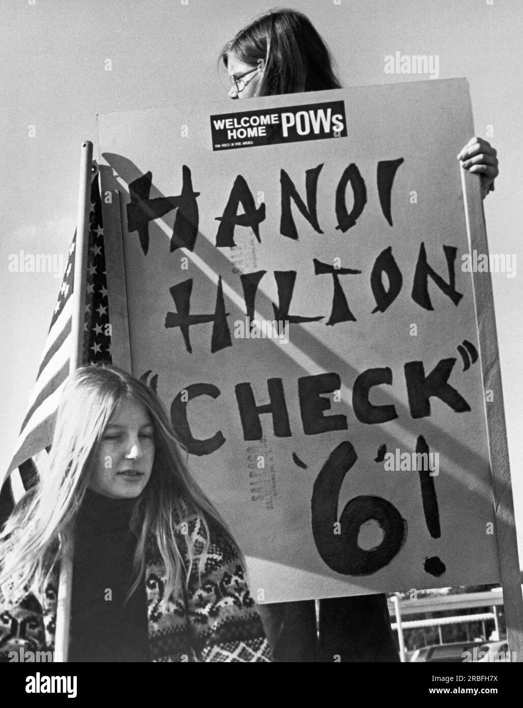 Fairfield, California:  February 16, 1973 A woman at Travis Air Force Base holding up a 'Hanoi Hilton, Check 6' sign as a plane arrives carrying Vietnam War POWs. Stock Photo