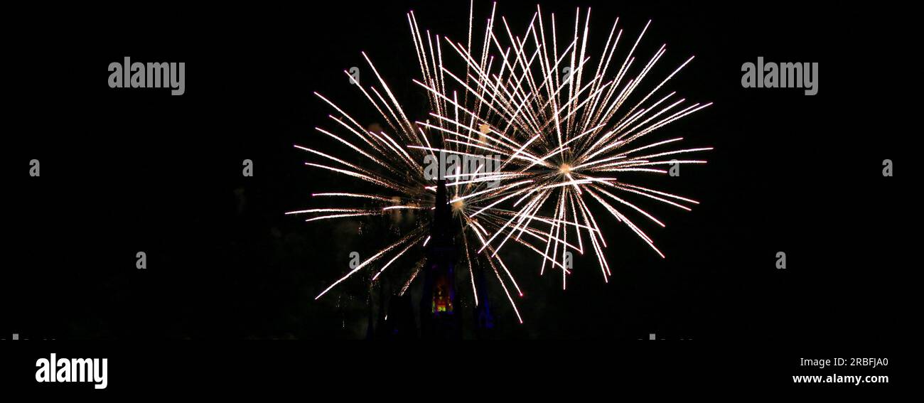 White fireworks exploading behind buildings during a fireworks show. Stock Photo