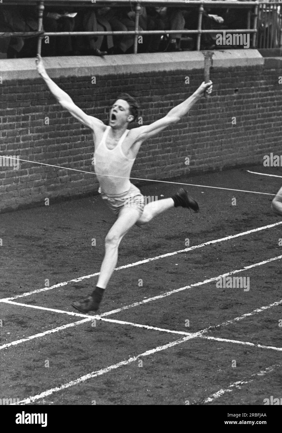 Philadelphia, Pennsylvania   1946 A runner in the relay event crosses the finish line at the Penn Relays Carnival. Stock Photo
