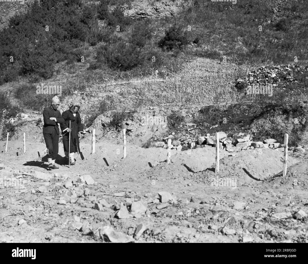 Korea:  December 13, 1950 A North Korean couple look for their son's grave at Duk San Nichel Mine where North Korean communists killed over 1000 anti-communists during their retreat. Stock Photo