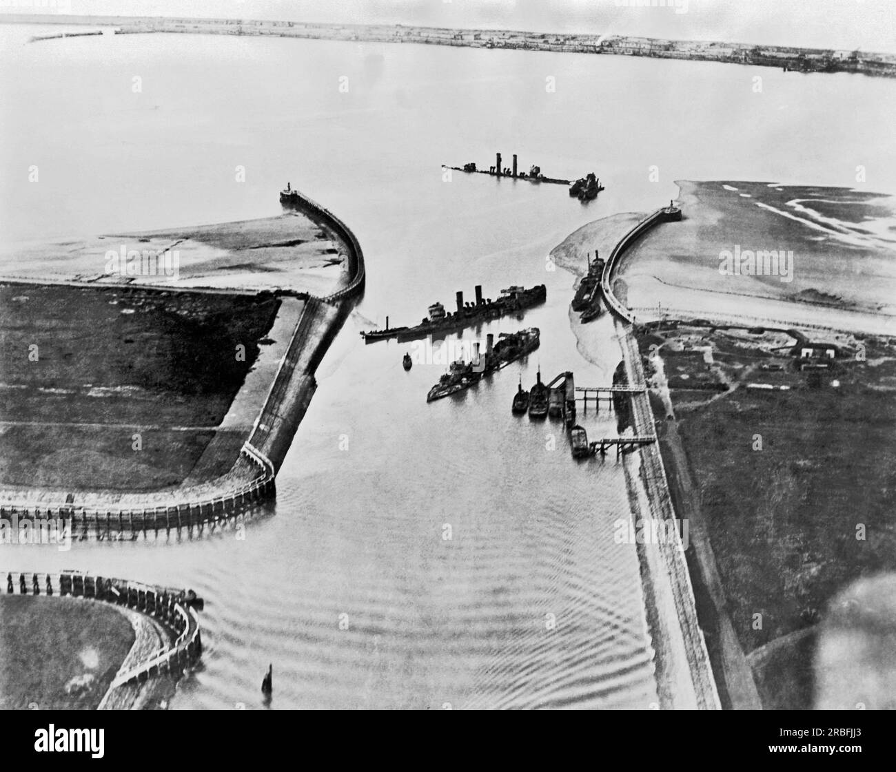 Zeebrugge, Belgium:  April, 1918 An aerial view of the entrance to the Bruges Canal at Zeebrugge with the sunken British ships Thetis, Intrepid, and Iphigenia. It was an attempt to block the port which was used by the German Navy as a base for their U-boats, but largely failed. A dredge can be seen at right clearing a channel which the Germans could still use at high tide. Stock Photo