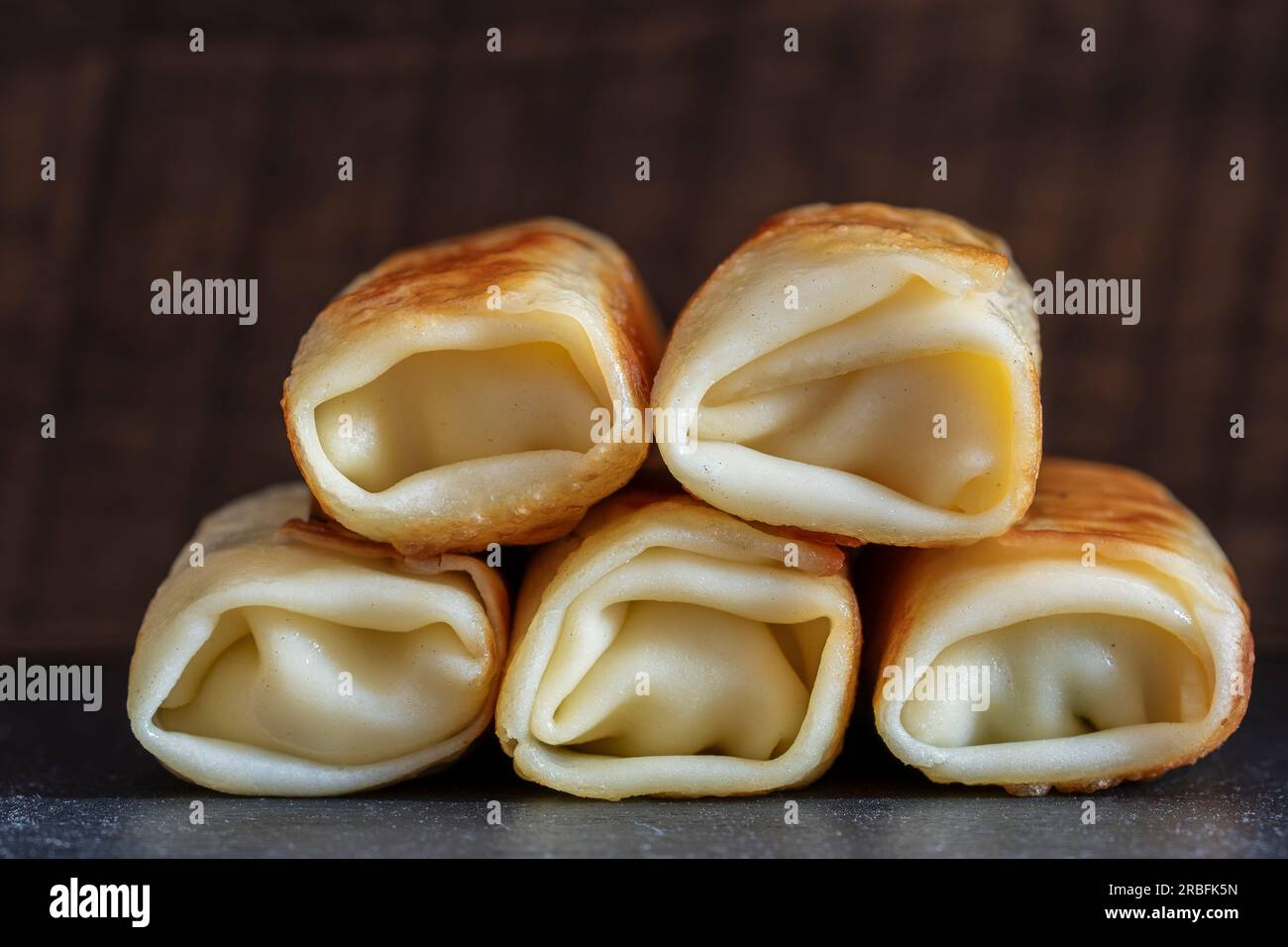 Stack of fried pancakes, close up. Traditional Ukrainian pancakes stuffed with meat filling. Homemade baking. Delicious fast food for breakfast Stock Photo