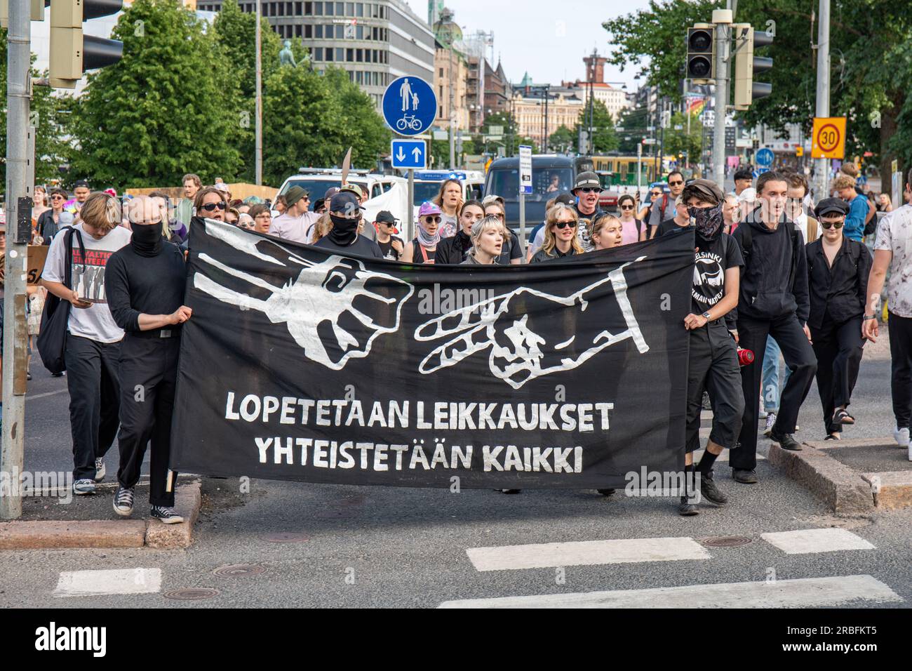 Lopetetaan leikkauset. Yhteistetään kaikki. Protesters carrying a banner at demonstration against right-wing government in Helsinki, Finland. Stock Photo