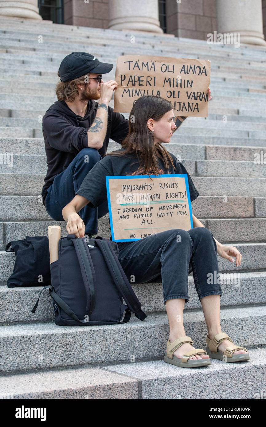 Protesters with cardboard signs on Parliament House steps at demonstration against right-wing government. Helsinki, Finland. Stock Photo