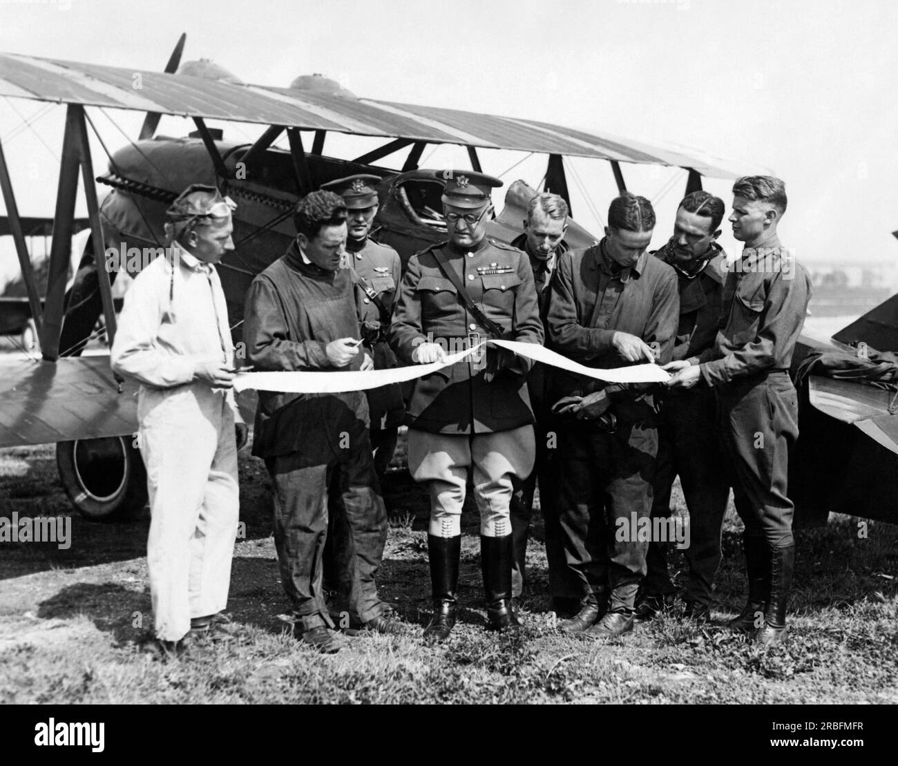 Maywood, Illinois:  July 20, 1925 Army pilots check their maps during their transcontinental flight between Selfridge Airfiled in  Harrison, Michigan and San Francisco, California. Behind them is one of the 5 Curtis P-! Hawks open cockpit biplane fighter aircrafts that they are flying. Stock Photo