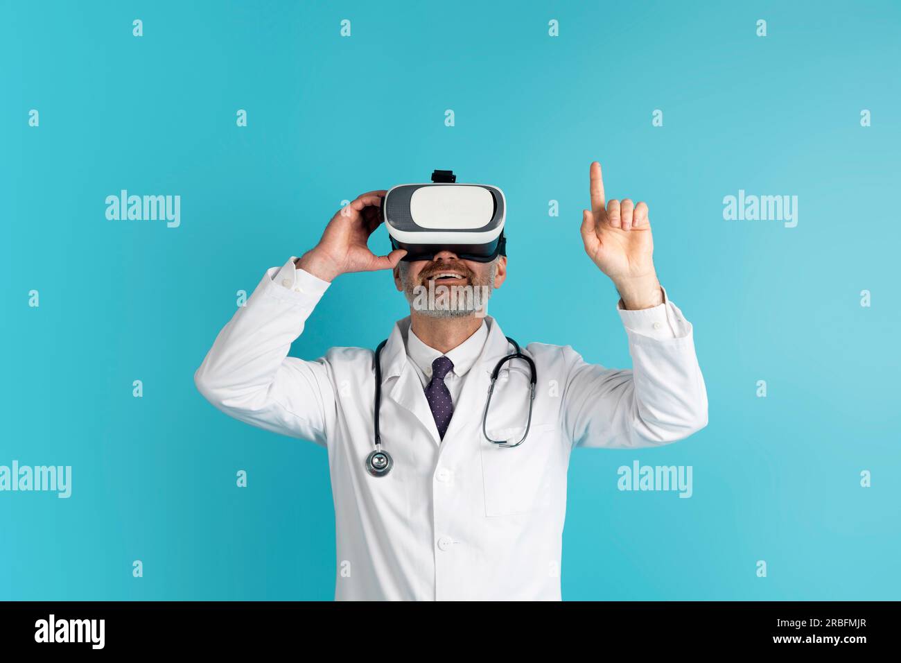 Doctor medical worker using virtual reality headset, blue background Stock Photo