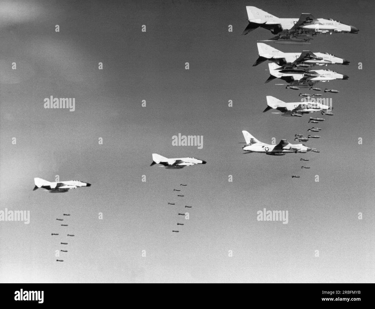 North Vietnam:  January 31, 1966 U.S. Air Force F-4C Phantom planes dropping bombs on Communist military targets in North Vietnam. The Phantom crews are guided under radar control by an Air Force B-66 Destroyer aircraft. Stock Photo