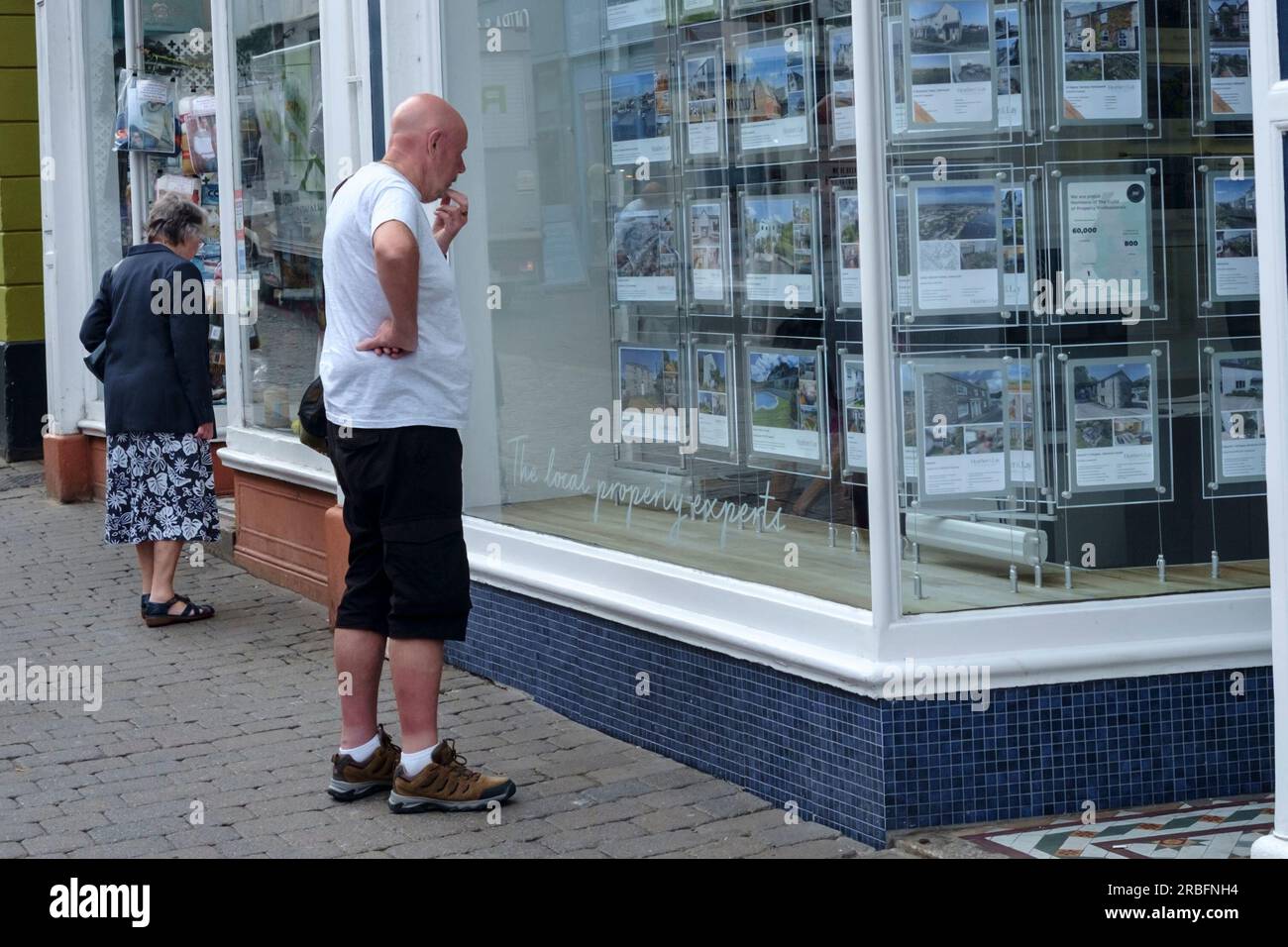Around Falmouth, a popular town in Cornwall UK. A man looks at an estate agent window. Stock Photo