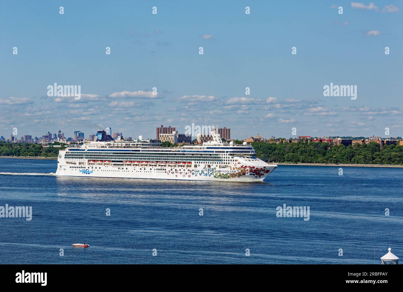 Norwegian Cruise Line’s Norwegian Gem, departing New York Harbor with Bay Ridge, Brooklyn as a backdrop, under bright skies. Stock Photo