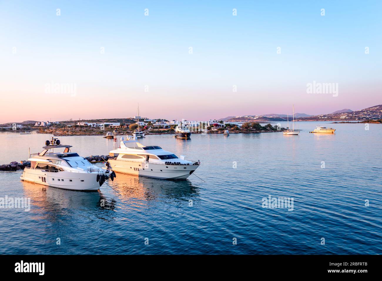 The port of Antiparos in the evening with Paros Island in the background. Cyclades Islands, Greece. Stock Photo