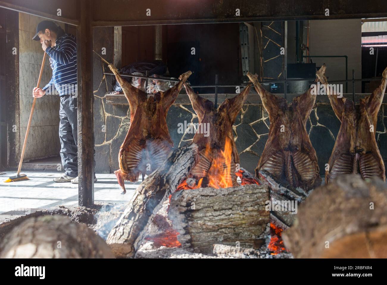 Man cooking the famous Fuegian lamb with a barbecue inside a restaurant, in Ushuaia, Argentina Stock Photo